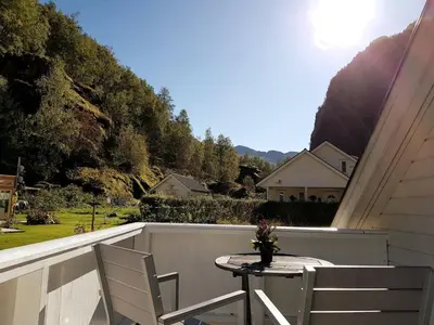 a table and two chairs on a balcony with a view at Bright and cozy apartment 1.5km from city centre in Aurland