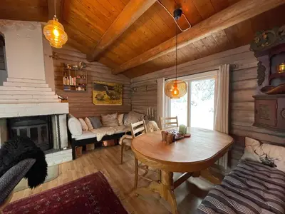 a living room with a table and a fireplace at Buhaug - cabin at Sjusjøen in Sjusjøen