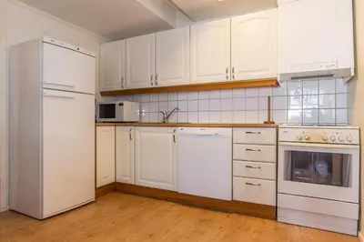 a kitchen with white appliances and white cabinets at Skitorget Apartments in Trysil