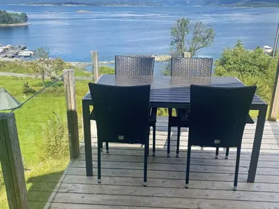 a table and chairs on a deck with a view of the water at 4 person holiday home in LINDÅS-By Traum in Lindås