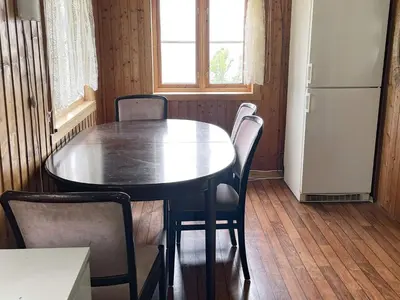 a dining room with a table and chairs and a refrigerator at 4 person holiday home in LINDÅS-By Traum in Lindås