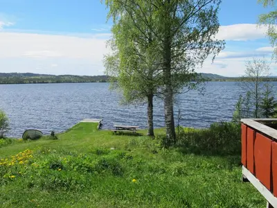 a picnic table on the shore of a lake at Festly in Ringsaker
