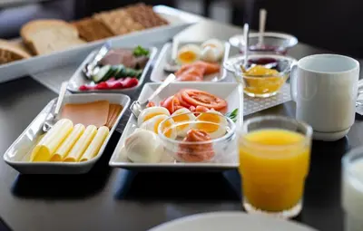 a table with a tray of food and orange juice at Sjøholt Sommerhotell in Ørskog
