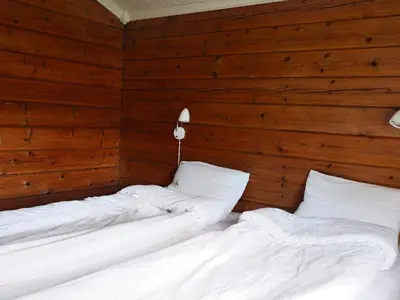 two beds in a room with wooden walls at 4 person holiday home in Utvik-By Traum in Utvik