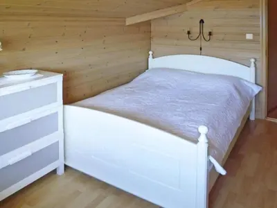 a bedroom with a white bed and a wooden wall at 6 person holiday home in TYSSE-By Traum in Tysse