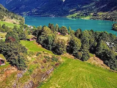 an aerial view of a house on a hill with a lake at 6 person holiday home in olden in Olden