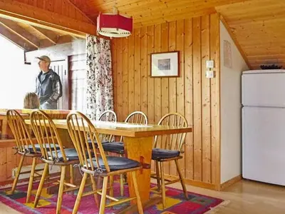 a man standing in a kitchen with a table and chairs at 6 person holiday home in olden in Olden
