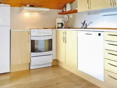 a kitchen with white appliances and wooden cabinets at 6 person holiday home in olden in Olden