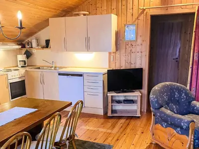 a kitchen with a table and a television in a room at 6 person holiday home in olden in Olden