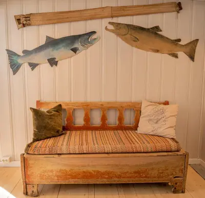 a bench with two fish hanging on a wall at Husum Hotel in Borgund