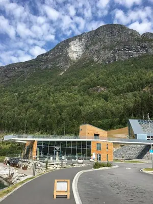 a large building with a mountain in the background at Fagre Stryn Feriehus in Stryn