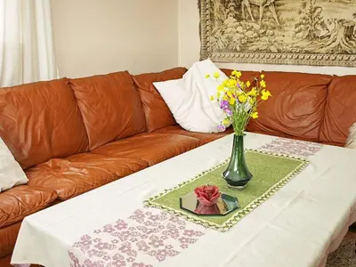 a couch with a vase of flowers on a table at 6 person holiday home in LONEVÅG-By Traum in Lonevåg