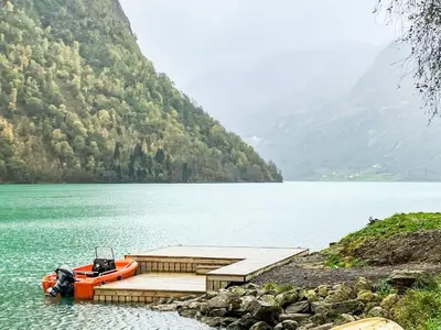 a boat is parked next to a dock on a lake at 6 person holiday home in olden-By Traum in Olden