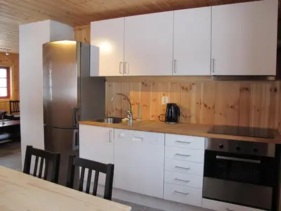 a kitchen with white cabinets and a stainless steel refrigerator at Hemsedal Høyfjellssenter in Hemsedal
