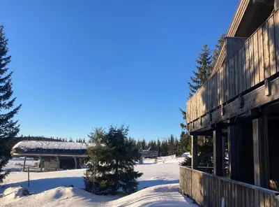 a building in the snow with a snow covered yard at Modern ski-in out apartment at Sjusjøen in Sjusjøen