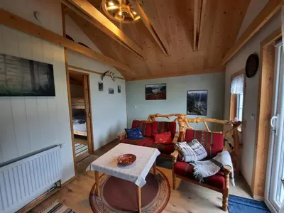 a living room with a couch and a table at Fjordgaestehaus in Innfjorden