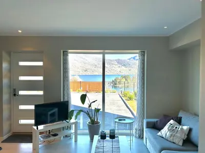 a living room with a blue couch and a sliding glass door at Havn i Etne with fjordview in Etnesjøen