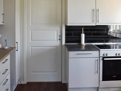 a kitchen with white cabinets and a white door at 6 person holiday home in SANDANE-By Traum in Sandane