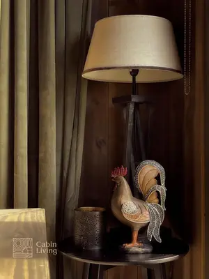 a lamp with a chicken on a table next to a lamp at Unique cabin with fantastic lake view, sauna, ski & EV outlet in Svingvoll