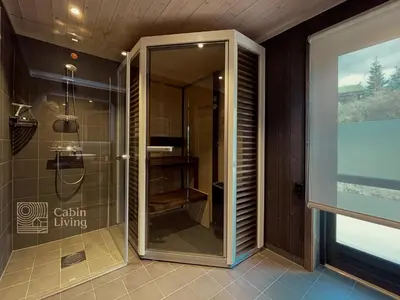a shower with a glass door in a bathroom at Unique cabin with fantastic lake view, sauna, ski & EV outlet in Svingvoll