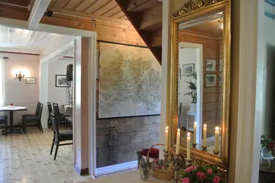 a hallway with a mirror and a dining room at Eide Gardshotell in Skjolden
