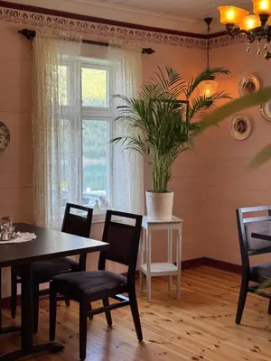 a dining room with a table and chairs and a window at Eide Gardshotell in Skjolden