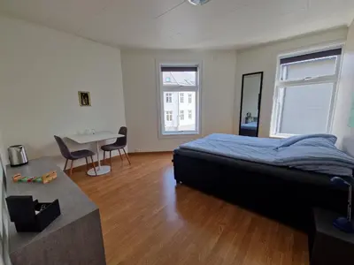 a bedroom with a bed and a table in it at Cozy Retreat in the Heart of Ålesund in Ålesund