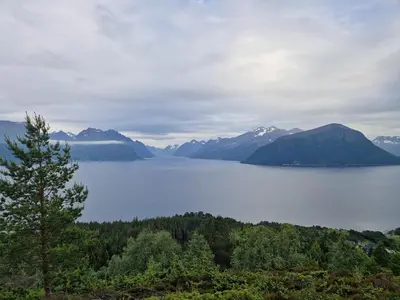 a view of a lake with mountains in the background at Cozy Retreat in the Heart of Ålesund in Ålesund
