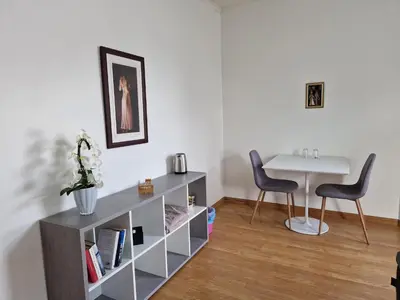 a living room with a table and two chairs at Cozy Retreat in the Heart of Ålesund in Ålesund
