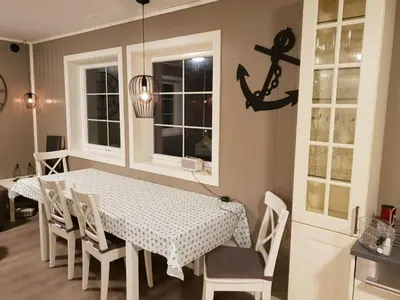 a dining room with a white table and chairs at Havglimt in Oksvoll