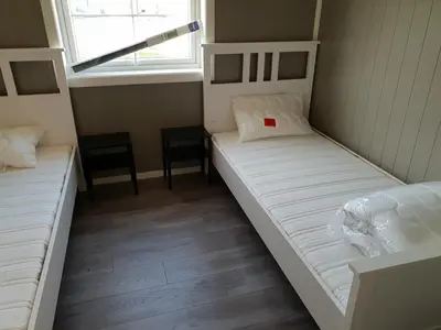 two beds in a small room with a window at Havglimt in Oksvoll
