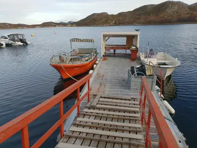 two boats are docked at a dock in the water at Havglimt in Oksvoll
