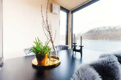 a living room with a table with a plant on it at Mikrohyttene i Åkrafjorden in Etnesjøen