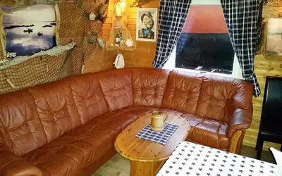 a brown leather couch in a living room with a table at Havgløtt in Oksvoll