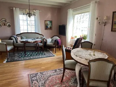 a living room with a table and chairs at Sjarmerende hus med veldig stort uteareal. in Brekstad