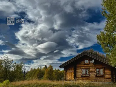 a wooden cabin under a cloudy sky at Cozy cabin at Beitostølen with sauna, hot tub & fireplace in Beitostøl