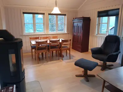 a living room with a table and chairs and a tv at Hatlen View in Isfjorden