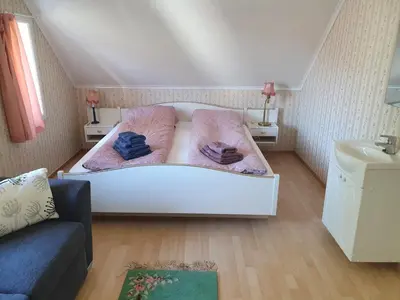 a small bedroom with two beds and a sink at Sjarmerende feriehus i Olden rett ved fjorden in Stryn