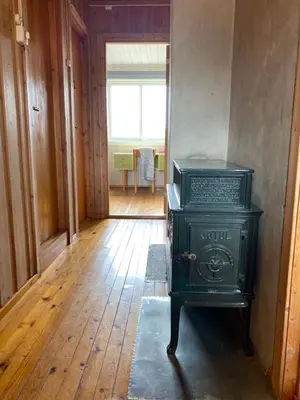 a green stove in a room with a hallway at Stort og autentisk hus i Skjåk - kort vei til Lom! in Skjåk