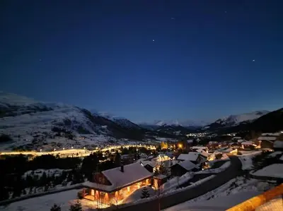 a town covered in snow at night with lights at Cabin in beautiful surroundings at Harpefossen in Nordfjordeid