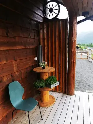a wooden porch with a chair and a table at Cabin in beautiful surroundings at Harpefossen in Nordfjordeid