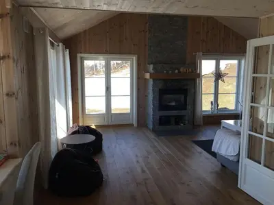 a living room with a fireplace and two windows at Holiday cottage with 4 bedroom on 145m² in Sogndal in Sogndal
