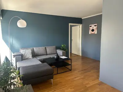 a living room with a couch and a table at Ålesund Urban - Spacious and luminous 100 m2 urban flat with 3 large bedrooms in Ålesund