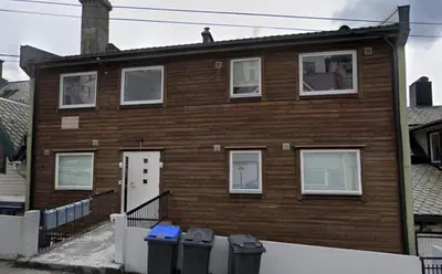 a wooden house with four windows and four trash at Ålesund Urban - Spacious and luminous 100 m2 urban flat with 3 large bedrooms in Ålesund