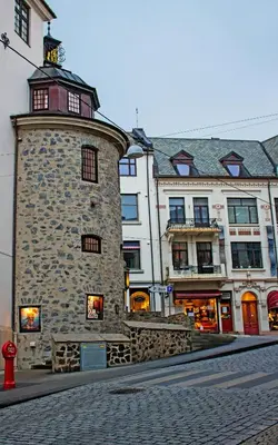 a large stone building with a clock tower on a street at Ålesund Urban - Spacious and luminous 100 m2 urban flat with 3 large bedrooms in Ålesund
