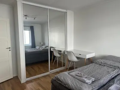 a bedroom with a bed and a desk with a mirror at Ålesund Urban - Spacious and luminous 100 m2 urban flat with 3 large bedrooms in Ålesund