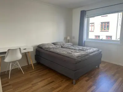 a bedroom with a bed and a desk and a window at Ålesund Urban - Spacious and luminous 100 m2 urban flat with 3 large bedrooms in Ålesund