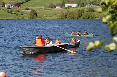 a group of people in boats on a lake at Lyngmo Gjestehus in Hafslo