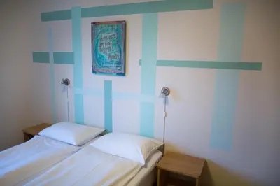 a bedroom with two beds and a picture on the wall at Lyngmo Gjestehus in Hafslo