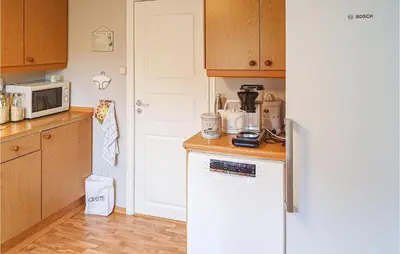 a kitchen with a white refrigerator and a microwave at 3 Bedroom Awesome Home In Skjold in Skjold